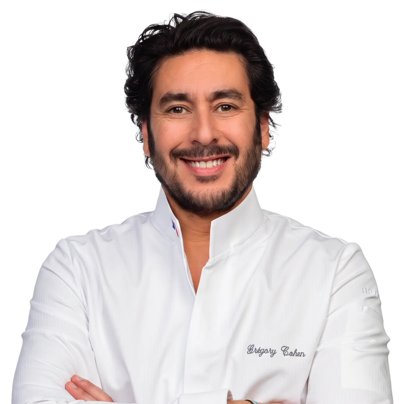 Grégory Cohen, souriant, bras croisés, en veste de chef blanche brodée à son nom