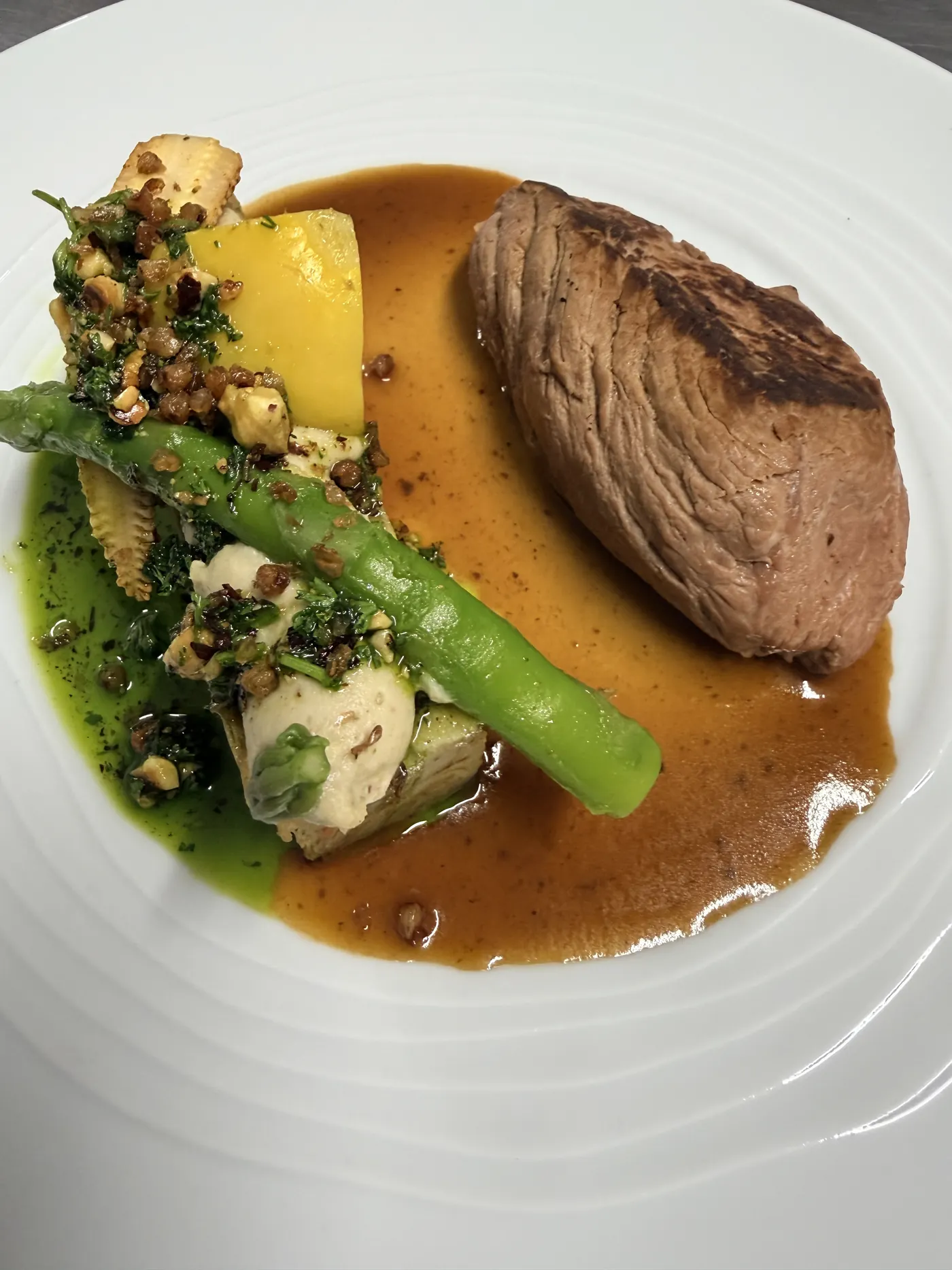 Pièce de bœuf, asperge verte et jus, dressée à l'assiette