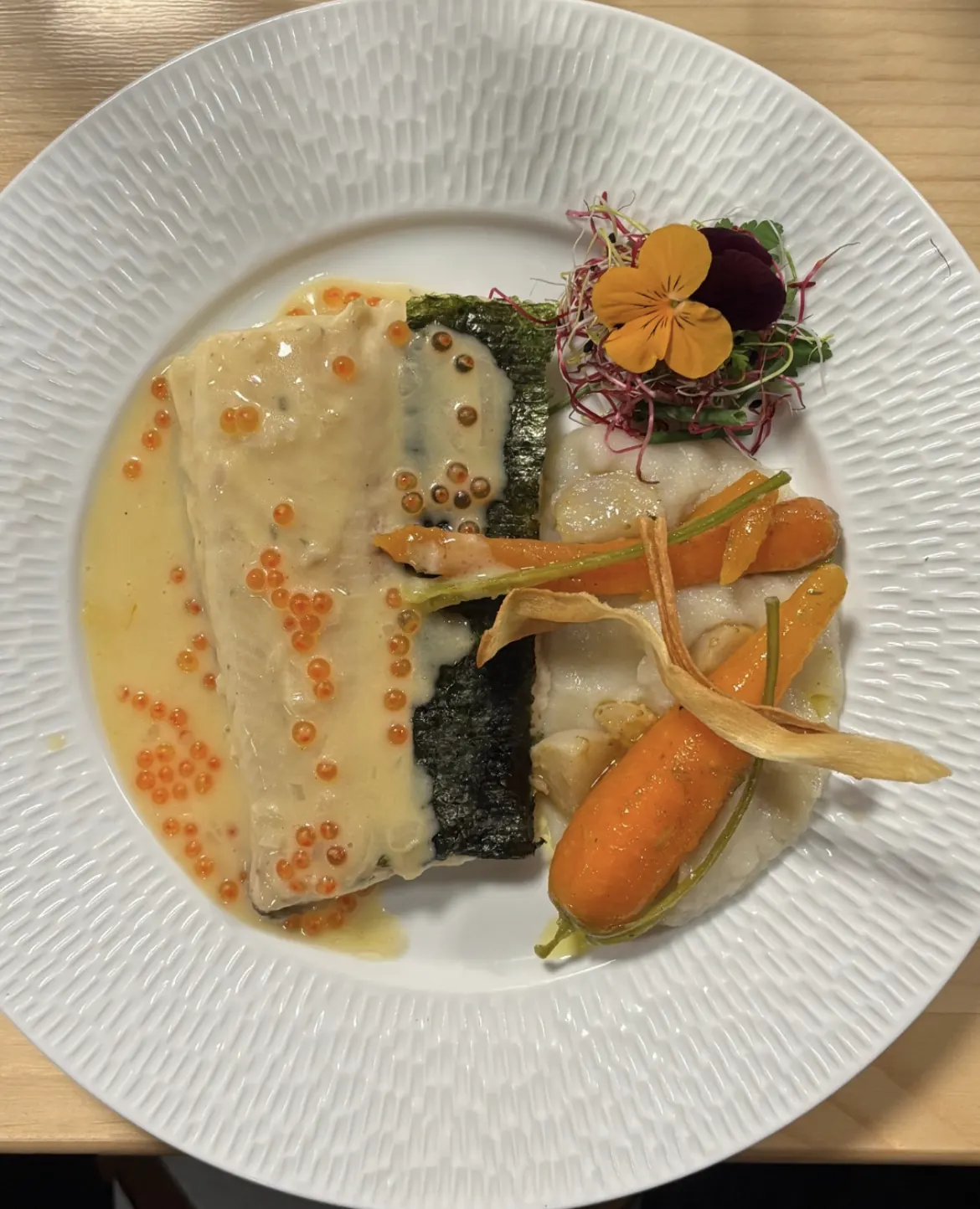 Plat signature : poisson, œufs de truite et fleurs comestibles